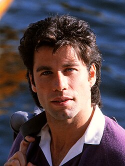Vintage portrait of a man in his late twenties holding a jacket near the water